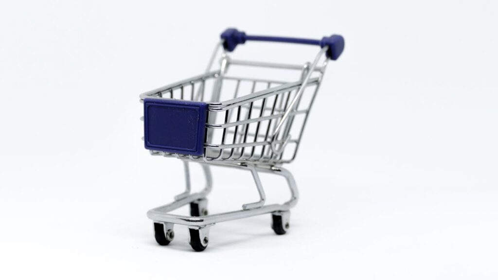 A modern miniature shopping cart on a clean white background, perfect for e-commerce concepts.